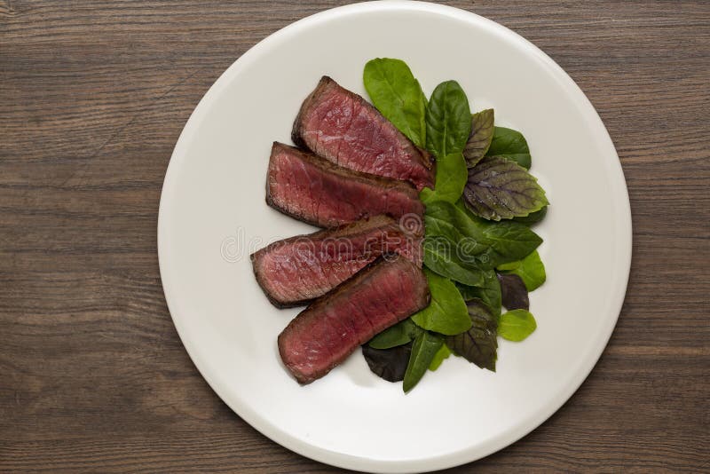 Juicy steak medium rare beef with green salad and tomatoes stock photography Juicy steak medium rare beef with green salad and tomatoes stock photography