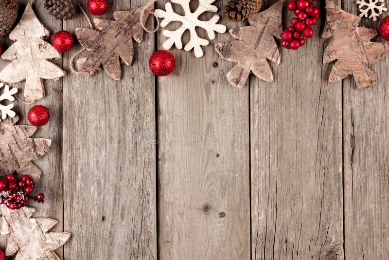 Rustic Christmas corner border with wood ornaments and berries on an aged wood background. Rustic Christmas corner border with wood ornaments and berries on an aged wood background