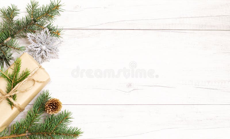 Julbakgrund Glad nyårssammansättning julklapp, pinjekonar, grindgrenar på vita golv av trä arkivbilder