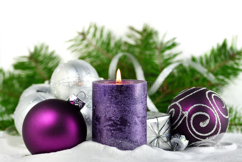 Julbakgrund med stearinljuset och garneringar Lilor och silverjulbollar över granträdfilialer i snön arkivbild Julbakgrund med stearinljuset och garneringar Lilor och silverjulbollar över granträdfilialer i snön arkivbild