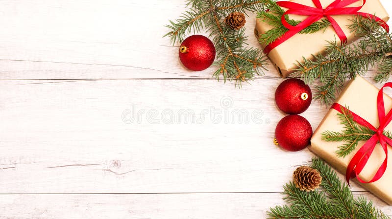 Julbakgrund och skrivbordsbakgrund Nyårssammansättning julklapp, rödbollar, pinjekonar, grindgrenar på trävitt arkivfoton