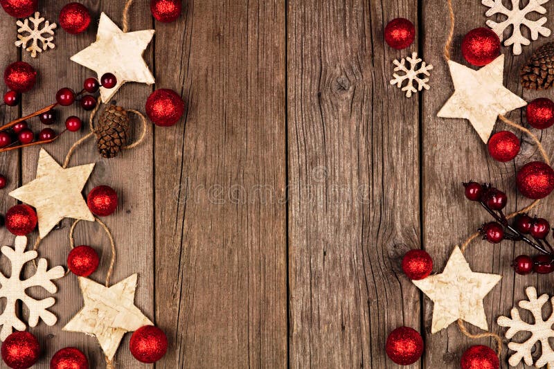 Christmas double side border with wood star ornaments and red baubles. Top view on a rustic wood background. Christmas double side border with wood star ornaments and red baubles. Top view on a rustic wood background