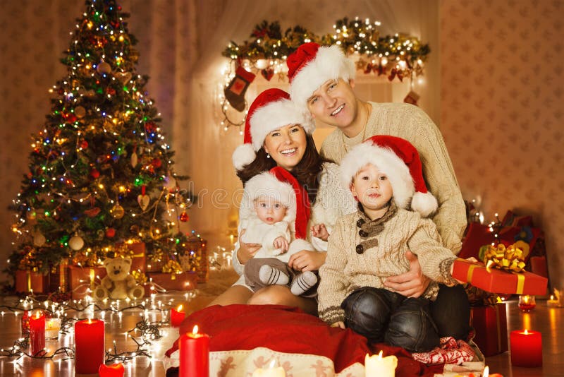 Julfamiljstående i hem- ferierum, på Santa Hat arkivfoto