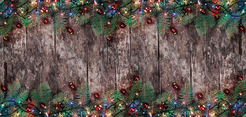 Julgran förgrena sig med ljus och röda garneringar på träbakgrund Sammansättning för Xmas och för lyckligt nytt år royaltyfri fotografi