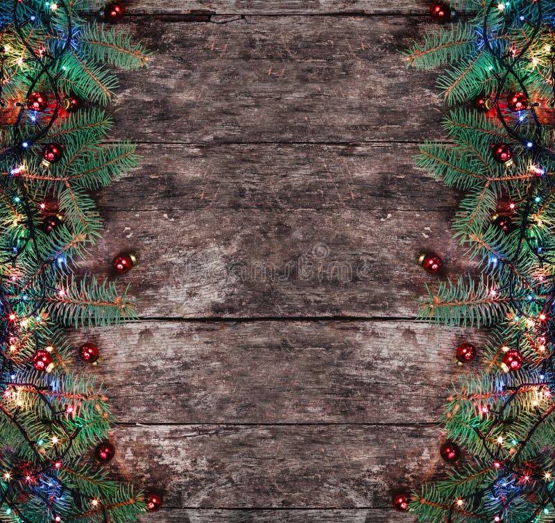 Julgran förgrena sig med ljus och röda garneringar på träbakgrund Sammansättning för Xmas och för lyckligt nytt år arkivbild