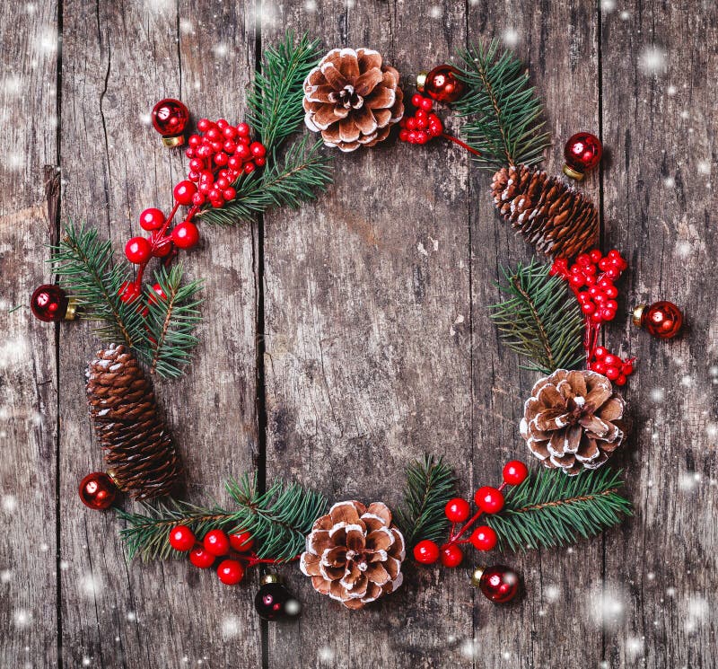 Julkransen av gran förgrena sig, kottar, röda garneringar på mörk träbakgrund Sammansättning för Xmas och för lyckligt nytt år arkivfoton