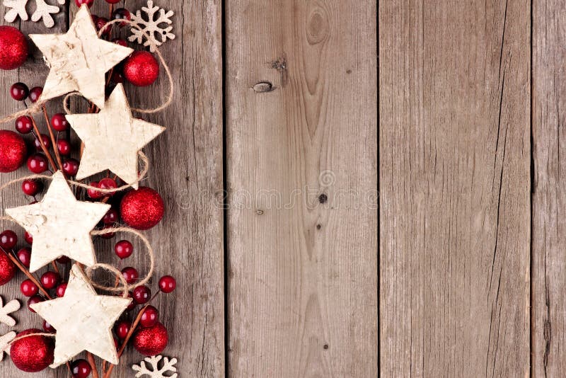 Julsidogräns med lantliga wood stjärnaprydnader och struntsaker på åldrigt trä arkivfoto Julsidogräns med lantliga wood stjärnaprydnader och struntsaker på åldrigt trä arkivfoto
