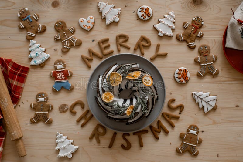 Julstämning. Traditionell homemade julkaka på ett träbord med ingerbröd och kakor i form av ingefärgbröd royaltyfria bilder