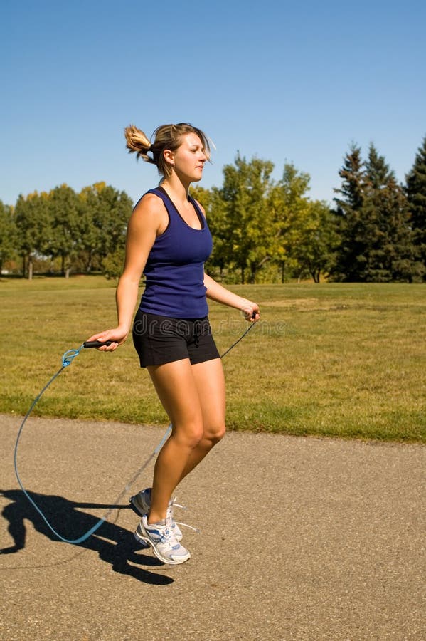 Young woman using a jump rope in a park.