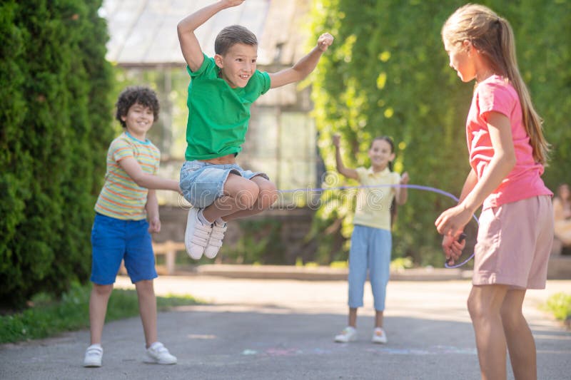 Jumping boy and friends with skipping rope