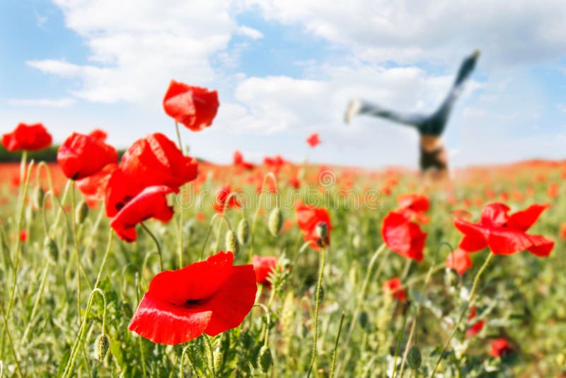 Jumping girl in poppy field