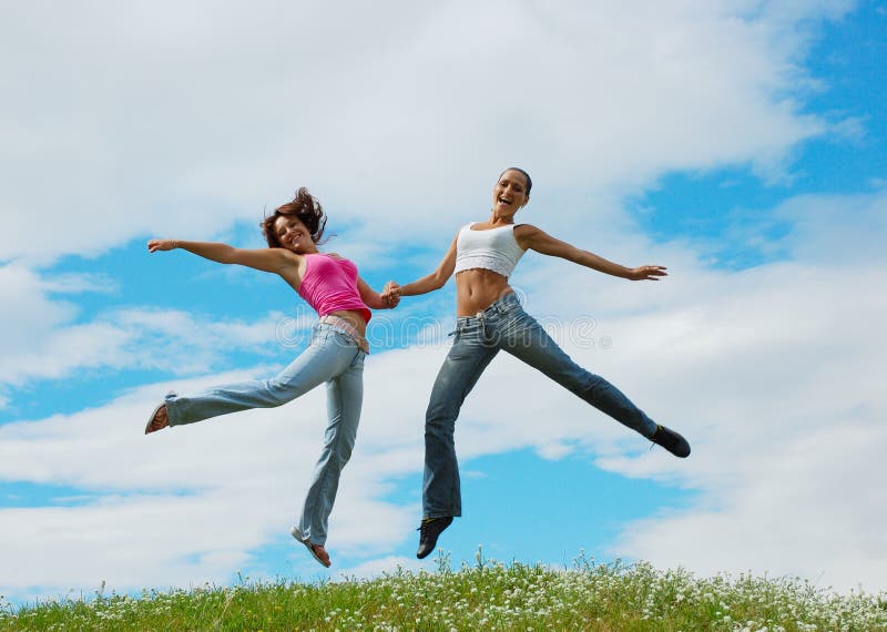 Jumping girls on meadow