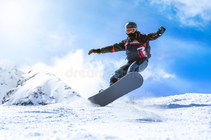 Jumping snowboarder from hill in winter stock image