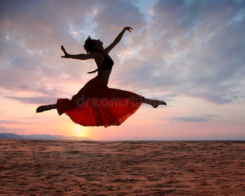 Imagen de una mujer saltando más alto Océano sobre el atardecer, silueta.