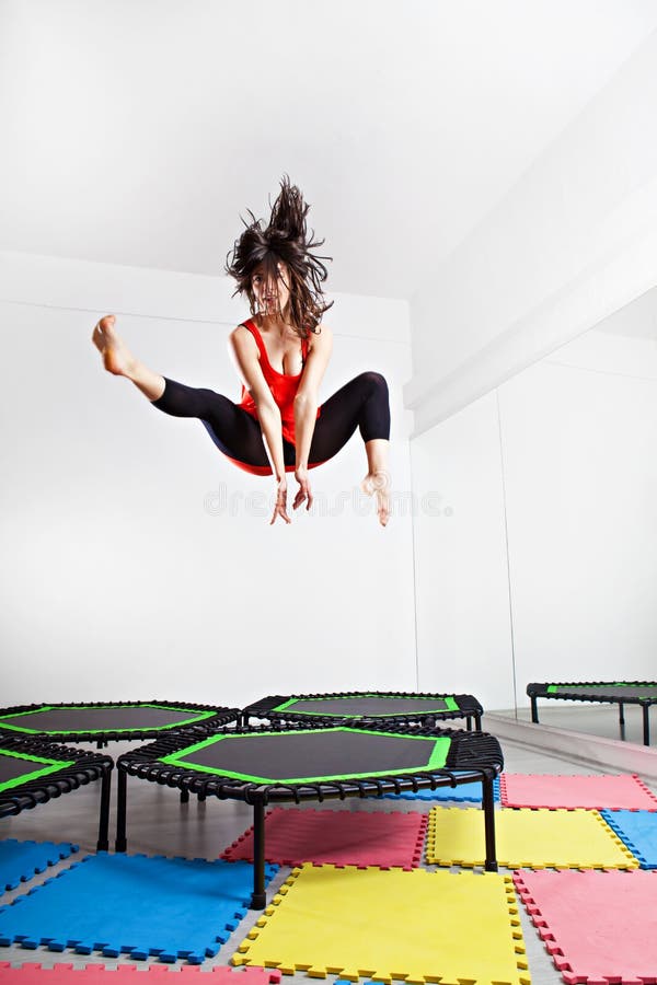 Jumping young woman on a trampoline royalty free stock photo.