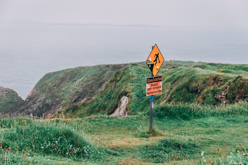 Warning signs of slippery surface and unprotected edges at the iconic Dunquin harbour pier surroundings in county Kerry stock photo Warning signs of slippery surface and unprotected edges at the iconic Dunquin harbour pier surroundings in county Kerry stock photo