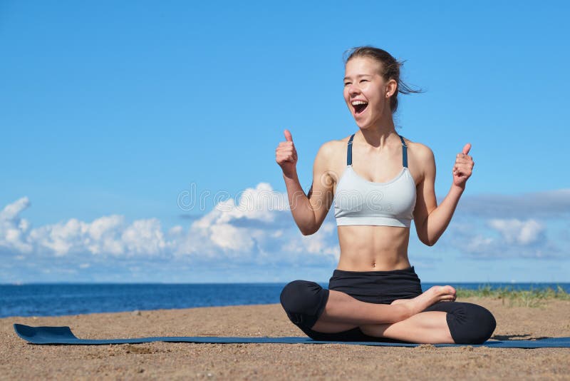 Young slim girl doing yoga on the beach on a sunny morning, positive attitude, healthy lifestyle. Young slim girl doing yoga on the beach on a sunny morning, positive attitude, healthy lifestyle.