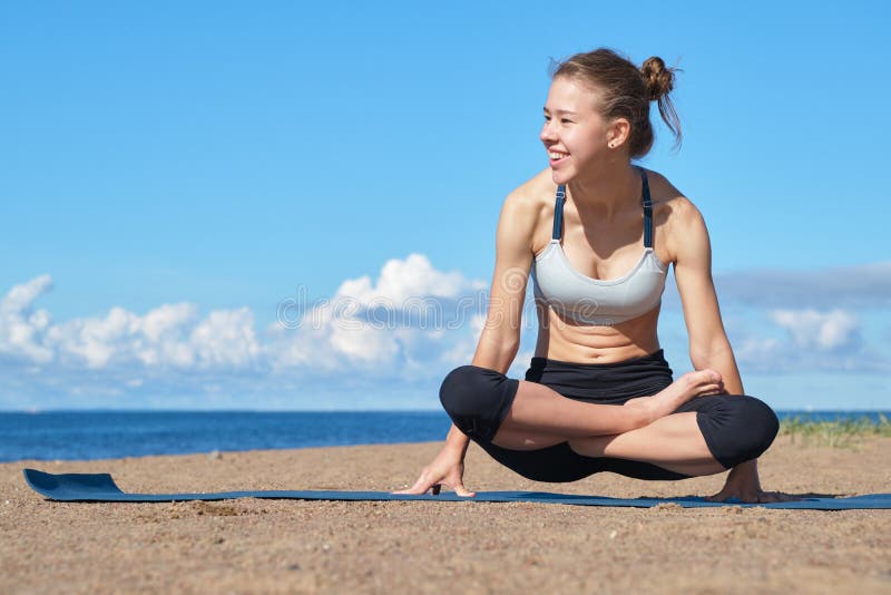 Young slim girl doing yoga on the beach on a sunny morning, positive attitude, healthy lifestyle. Young slim girl doing yoga on the beach on a sunny morning, positive attitude, healthy lifestyle.