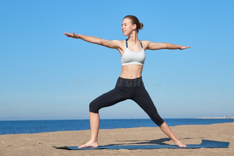 Young slim girl doing yoga on the beach on a sunny morning, positive attitude, healthy lifestyle. Young slim girl doing yoga on the beach on a sunny morning, positive attitude, healthy lifestyle.