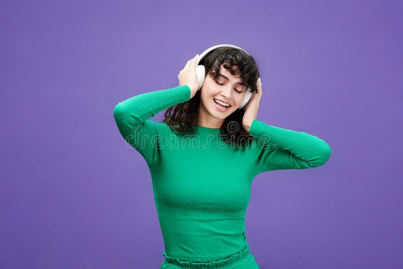 Jung fröhliche Brunette-Frau mit langgestrecktem Haar, die Musik hört stockfoto