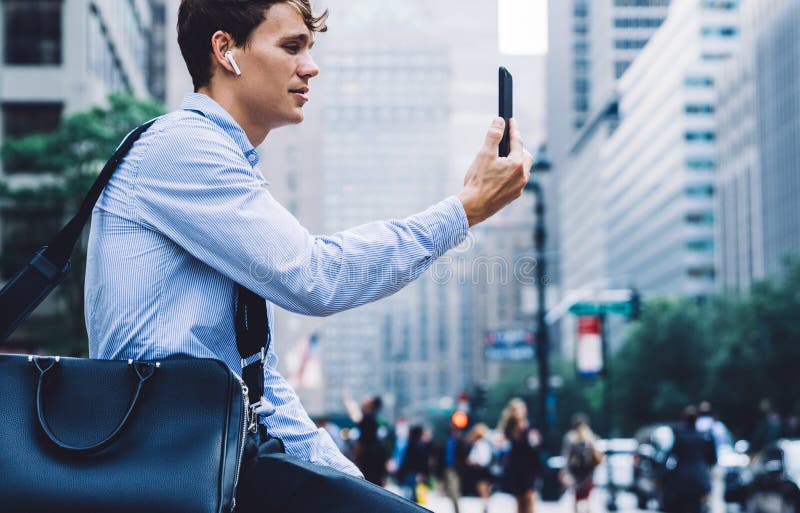 Jung stolze cein earbuds mit bluetooth für den Aufruf stockfotos