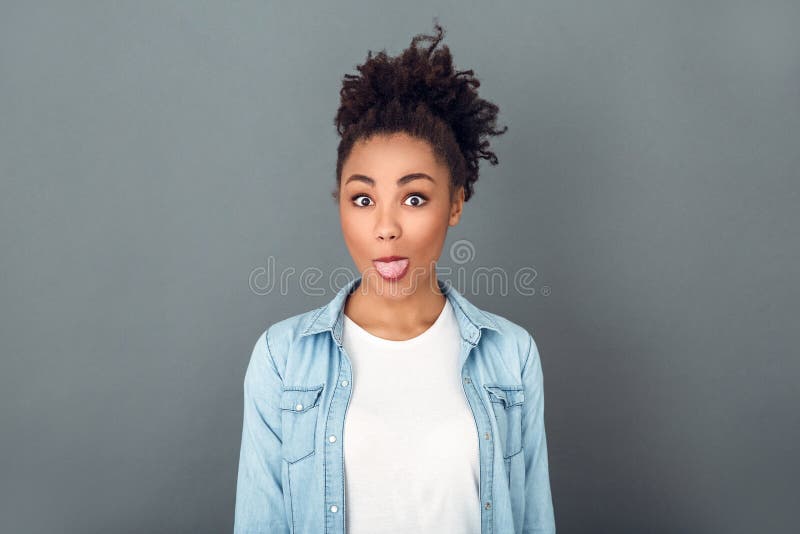 Junge afrikanische Frau heraus lokalisiert auf der Lebensstil-Zunge des grauen Wandstudios zufälligem täglichem Ausdruck lizenzfreie stockfotos Junge afrikanische Frau heraus lokalisiert auf der Lebensstil-Zunge des grauen Wandstudios zufälligem täglichem Ausdruck lizenzfreie stockfotos