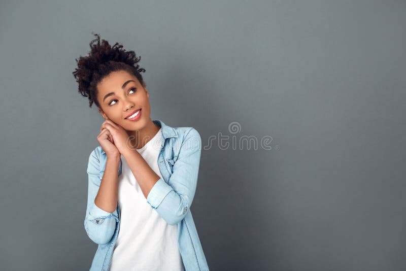 Junge afrikanische Frau lokalisiert auf dem zufälligen täglichen Lebensstilträumen des grauen Wandstudios lizenzfreie stockfotografie Junge afrikanische Frau lokalisiert auf dem zufälligen täglichen Lebensstilträumen des grauen Wandstudios lizenzfreie stockfotografie