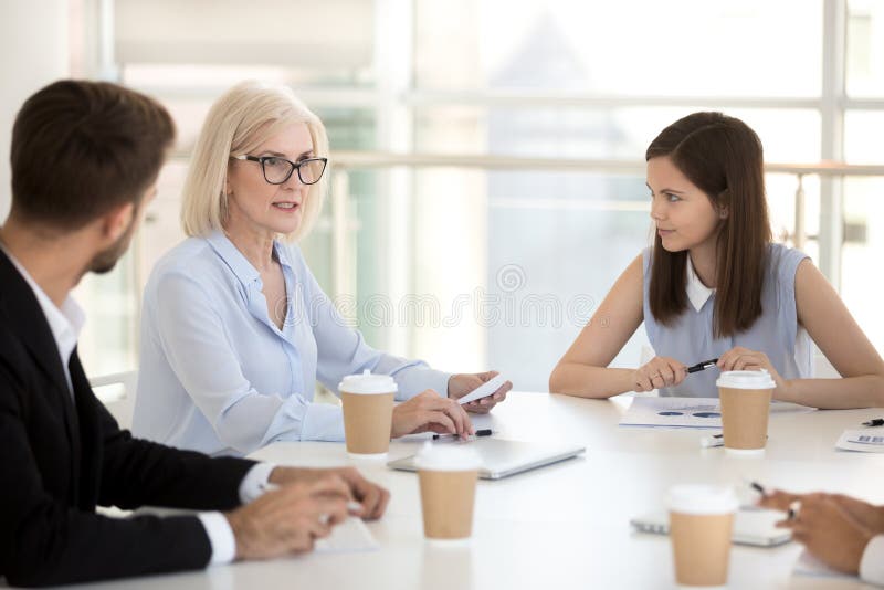 Junge Angestellte hören auf den weiblichen Chef, der während der Anweisung spricht