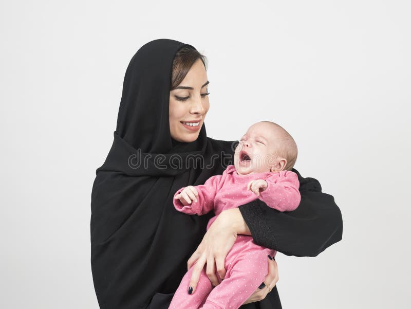 Junge arabische Mutter, die ihr kleines Baby hält lizenzfreies stockfoto Junge arabische Mutter, die ihr kleines Baby hält lizenzfreies stockfoto