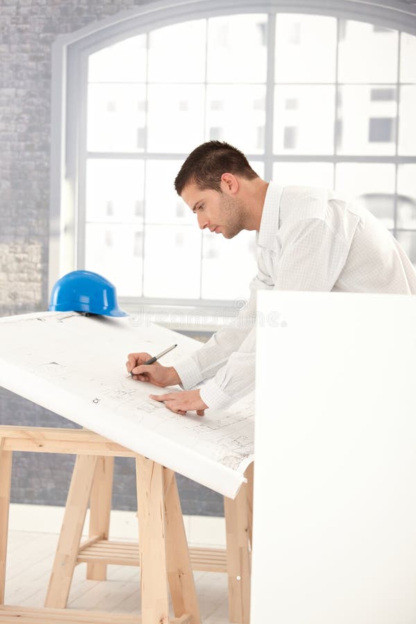 Junge Architektenzeichnungspläne stockfotos