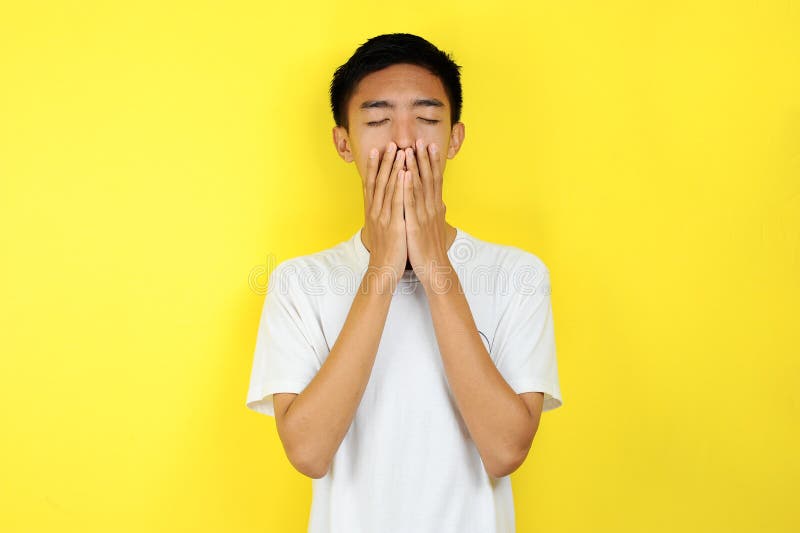 Junge Asiaten fühlen sich mit der Hand traurig in seinem Gesicht lizenzfreie stockbilder Junge Asiaten fühlen sich mit der Hand traurig in seinem Gesicht lizenzfreie stockbilder