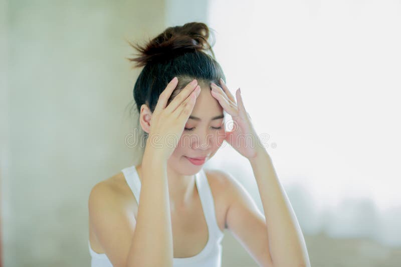Junge asiatische Frau, die ihren Kopf massiert stockbild Junge asiatische Frau, die ihren Kopf massiert stockbild