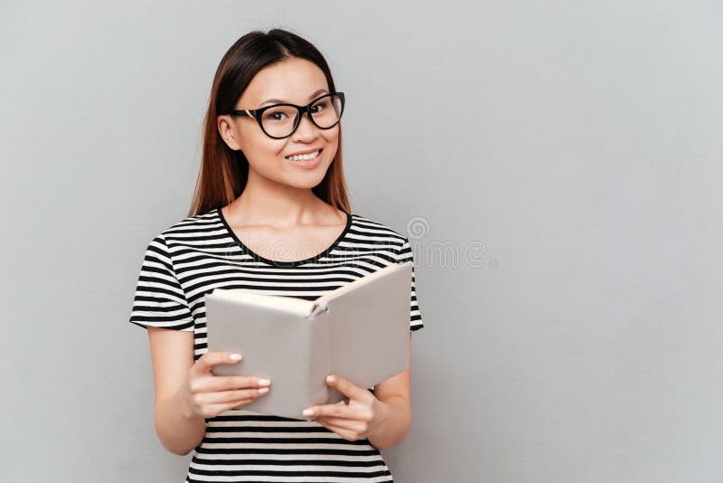 Junge asiatische Frau im Glaslesebuch stockfoto Junge asiatische Frau im Glaslesebuch stockfoto