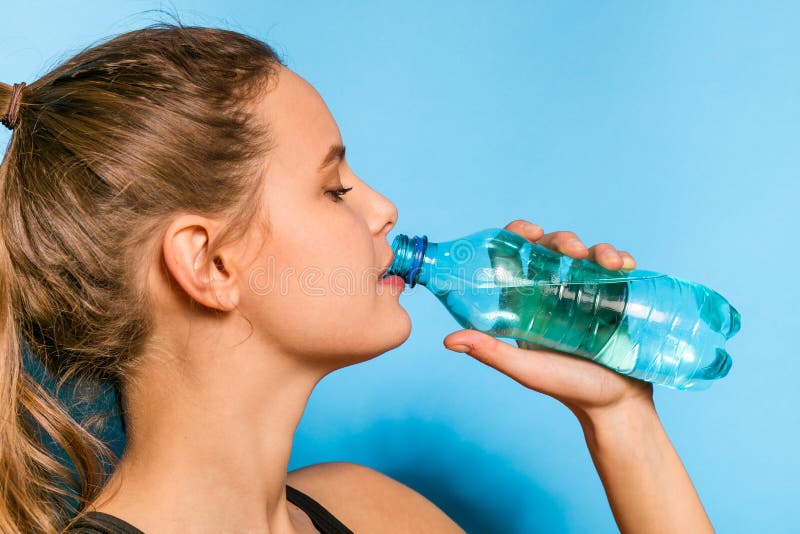 Junge athletische Frau mit einer Flasche Wasser stockbild Junge athletische Frau mit einer Flasche Wasser stockbild