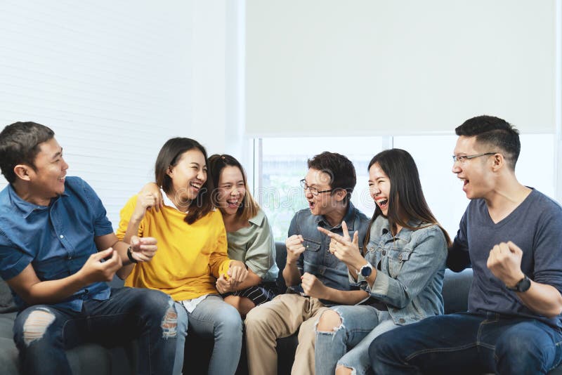 Junge attraktive asiatische Gruppe Freunde, die mit glücklichem sprechen und lachen, wenn die Sitzung erfasst wird, die zu Hause