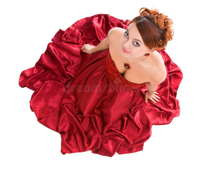 Junge attraktive Frau, die im roten Kleid sitzt stockfotos