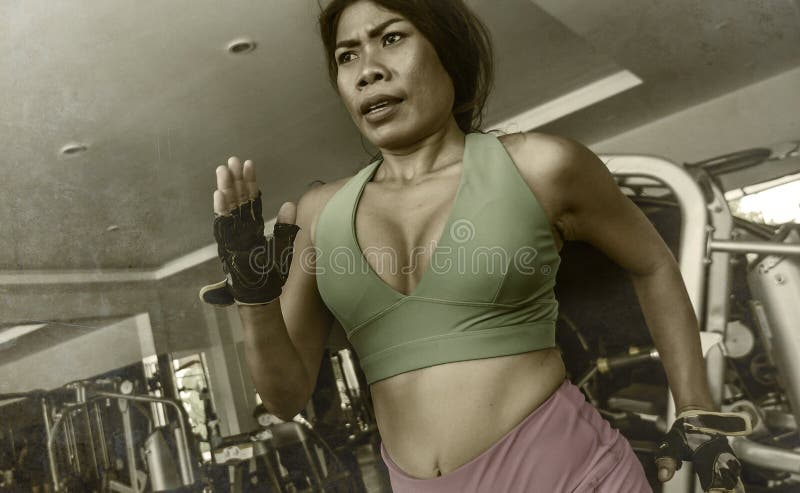 Junge attraktive und athletische asiatische indonesische Sportfrau, die auf Tretmühle am harten rüttelnden Training des Turnhalle stockbilder Junge attraktive und athletische asiatische indonesische Sportfrau, die auf Tretmühle am harten rüttelnden Training des Turnhalle stockbilder