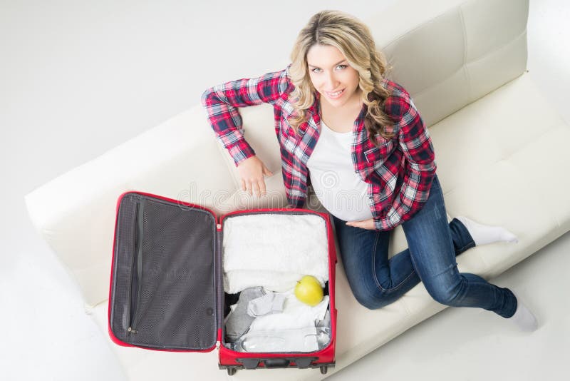 Junge attraktive Verpackungskinderkleidung der schwangeren Frau lizenzfreie stockfotografie Junge attraktive Verpackungskinderkleidung der schwangeren Frau lizenzfreie stockfotografie