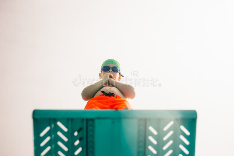 Junge auf Sprungturm am Pool