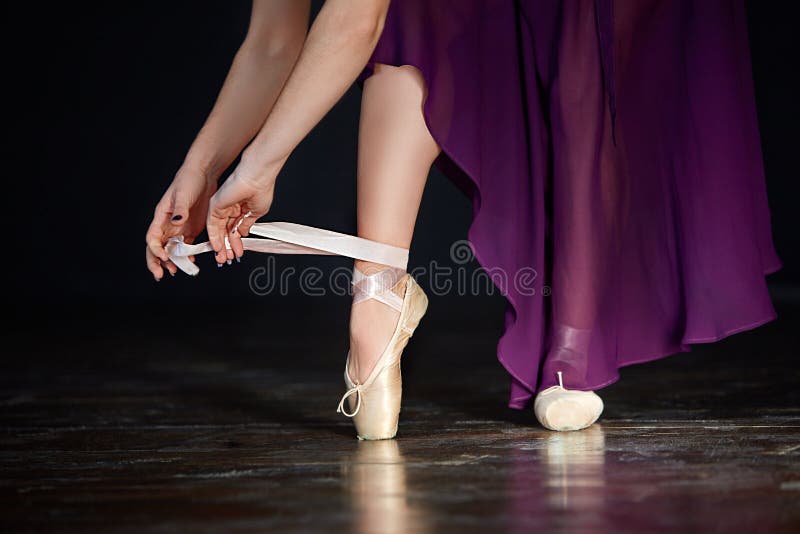 Junge Ballerina, die zu einem klassischen Tanz fertig wird Tragender Punkt des Mädchens beschuht Nahaufnahme auf dem dunklen Hint stockfotos Junge Ballerina, die zu einem klassischen Tanz fertig wird Tragender Punkt des Mädchens beschuht Nahaufnahme auf dem dunklen Hint stockfotos