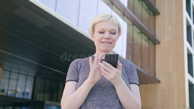 Junge blonde Dame Using ein Telefon in der Stadt stockfotos Junge blonde Dame Using ein Telefon in der Stadt stockfotos