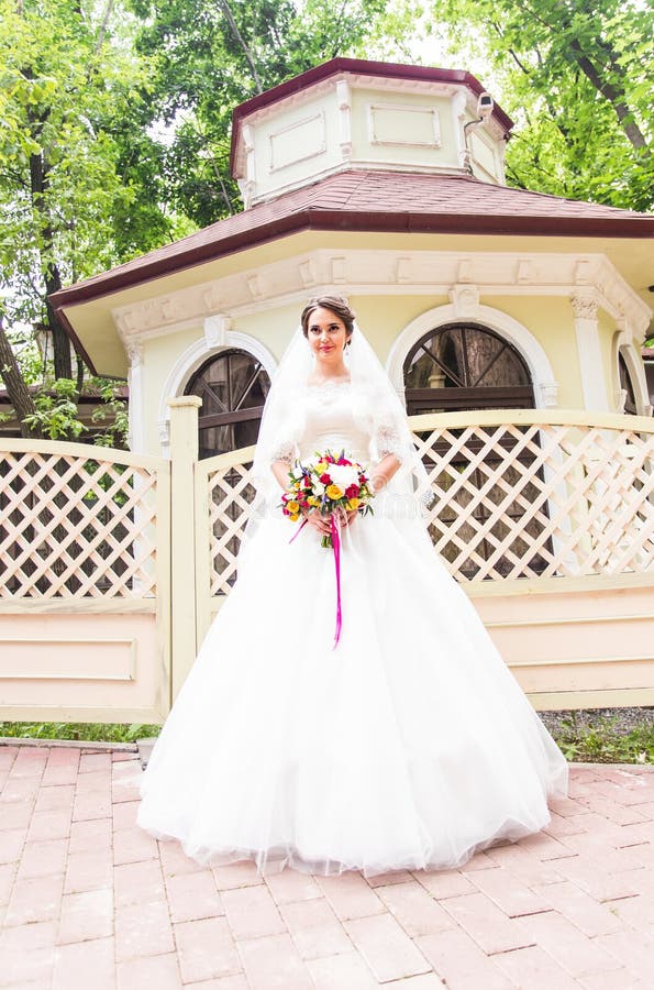 Junge Braut im Hochzeitskleid, das Blumenstrauß hält stockbilder Junge Braut im Hochzeitskleid, das Blumenstrauß hält stockbilder