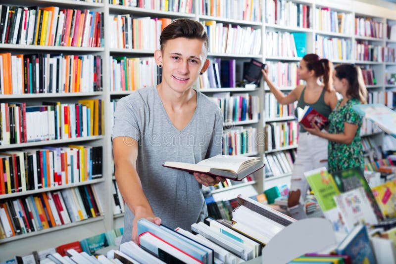 Junge, der Buch und das Schauen hält lizenzfreie stockfotografie Junge, der Buch und das Schauen hält lizenzfreie stockfotografie