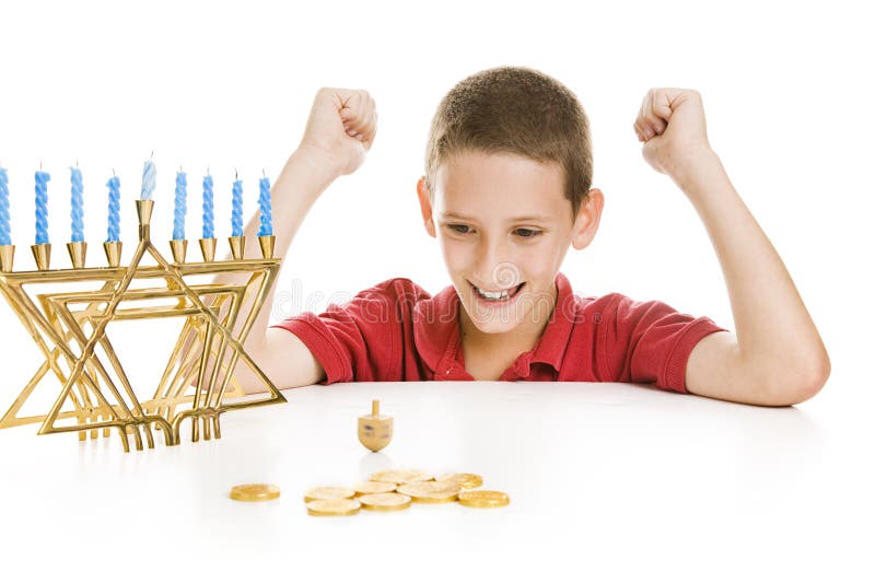 Junge, der das Chanukah Dreidel spinnt lizenzfreie stockbilder Junge, der das Chanukah Dreidel spinnt lizenzfreie stockbilder