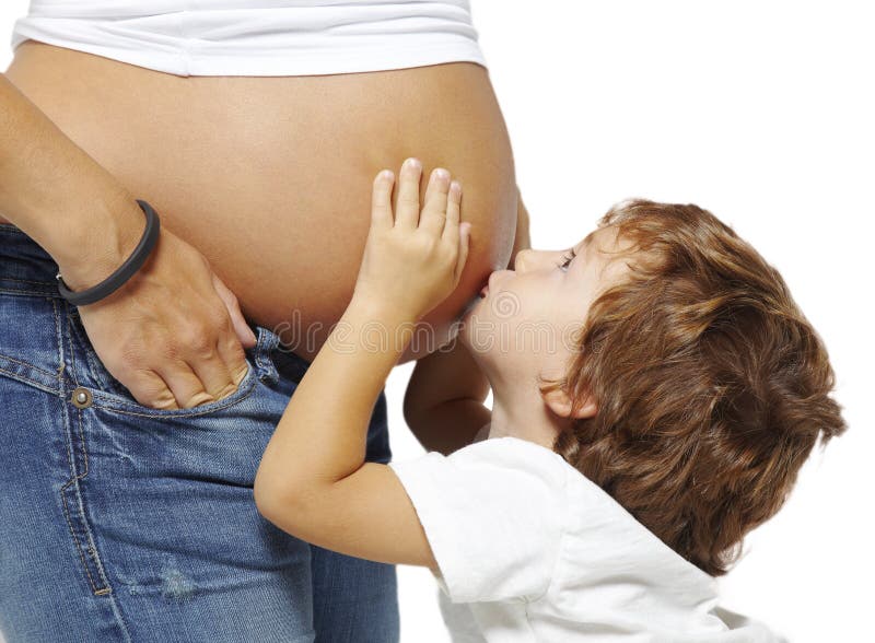 Junge, der den Bauch seiner schwangeren Mutter küßt