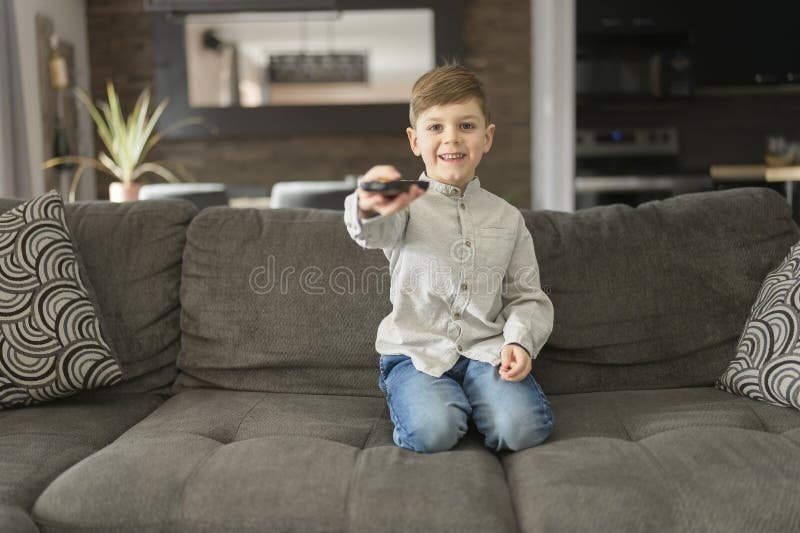 Ein Junge, der fernsieht, sitzt zu Hause auf dem Sofa