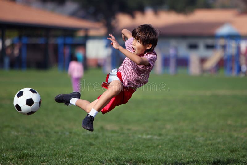 Junge, der Fußball im Park spielt lizenzfreies stockbild Junge, der Fußball im Park spielt lizenzfreies stockbild