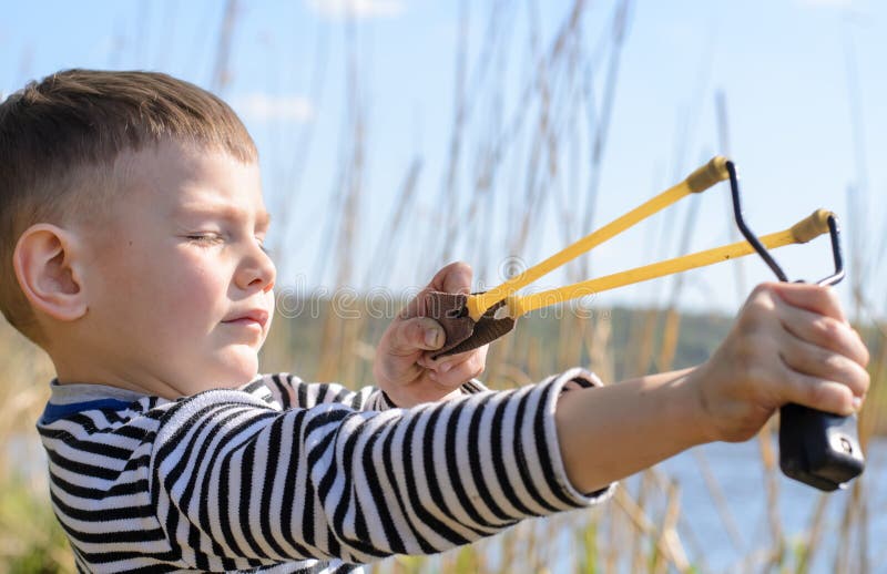 Junge, der Riemen-Schuss über See zielt lizenzfreies stockfoto Junge, der Riemen-Schuss über See zielt lizenzfreies stockfoto