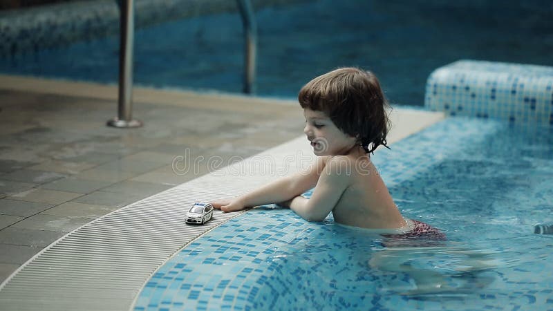 Junge Eltern, die mit seinem Sohn im Pool spielen