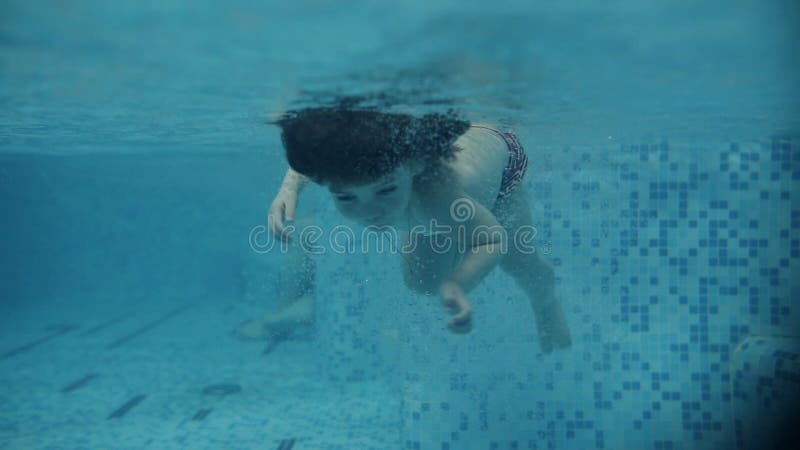 Junge Eltern im Pool seinen Sohn unterrichtend, unter Wasser zu schwimmen